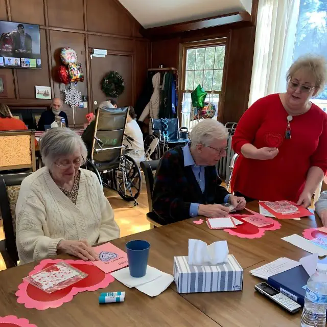 Seniors at Old Glory Days in Watertown, CT, participating in a Valentine’s Day craft activity with staff assistance in a warm, engaging environment. Old Glory Days Testimonials